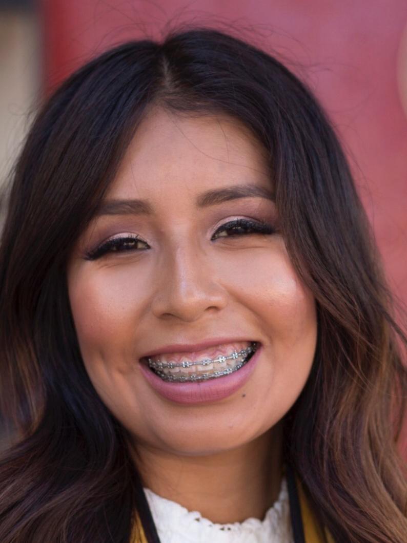 A person with long hair smiling.