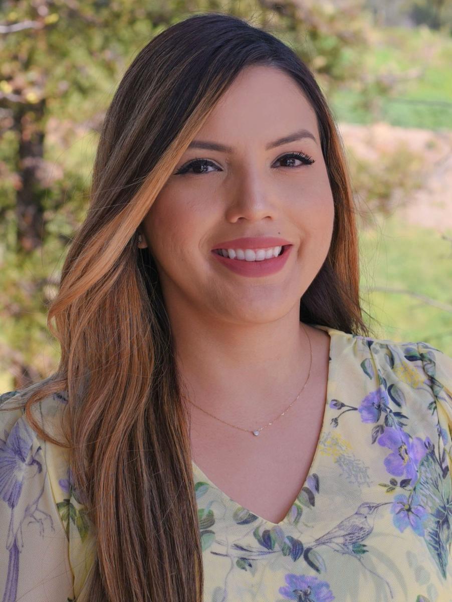 A person with long hair smiling.