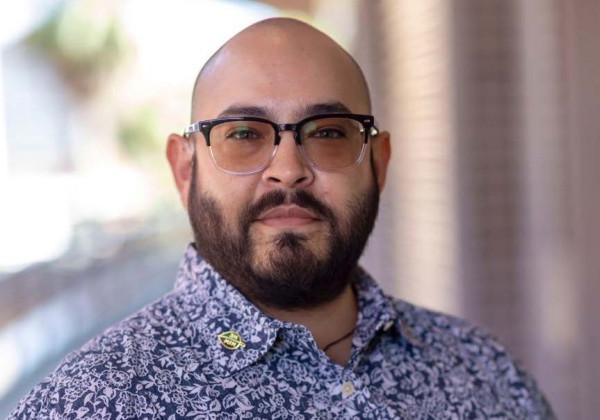 A person with a beard waring glasses.