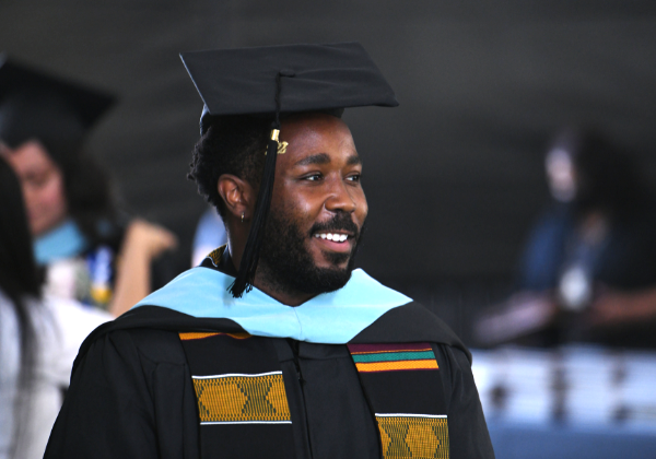 Male graduate wearing cap and gown.