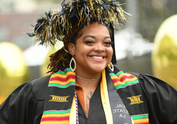 Female graduate in festive cap and gown.