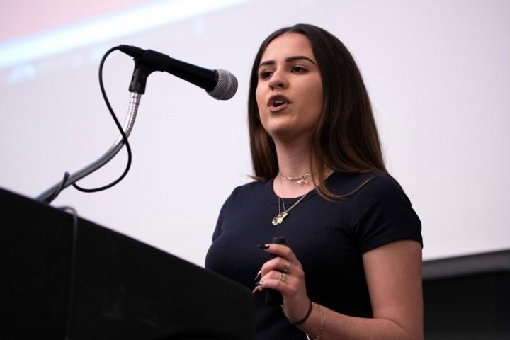 Woman in from of microphone speaking