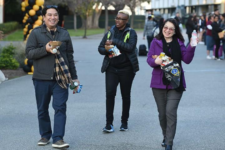 Three staff members walking down the main walkway.