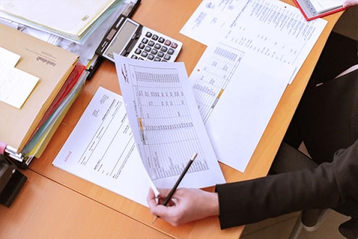 table covered with papers and calculator