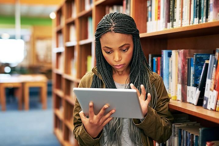 Student looking at an iPad while at the library