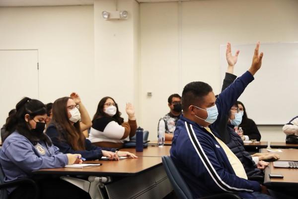 Students raising hands engaged at event