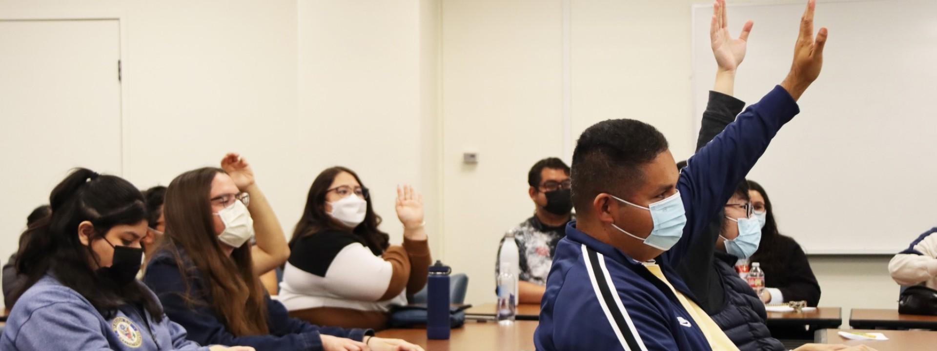 Students raising hands engaged at event